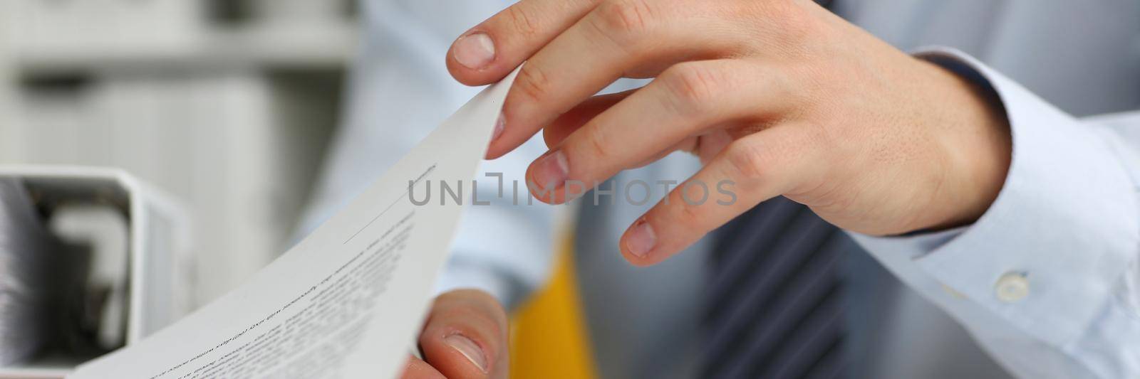 Male hands hold documents with financial statistics in closeup. Tax service income list concept