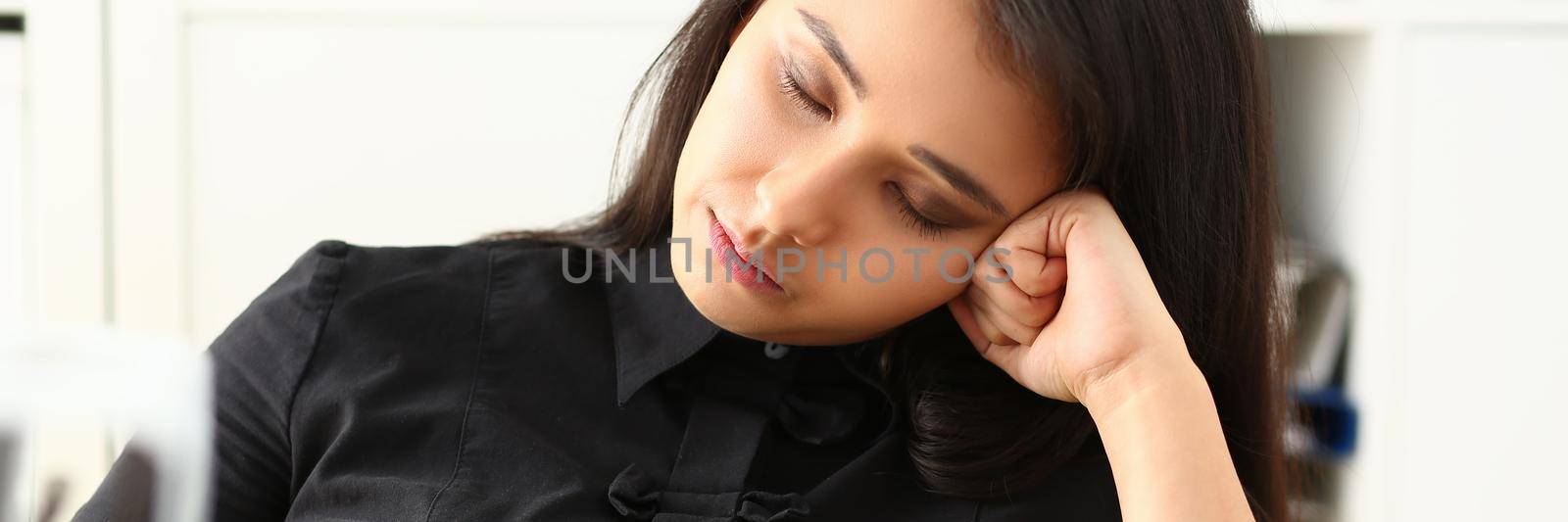 Tired and exhausted woman who works lot with documents falls asleep at workplace by kuprevich