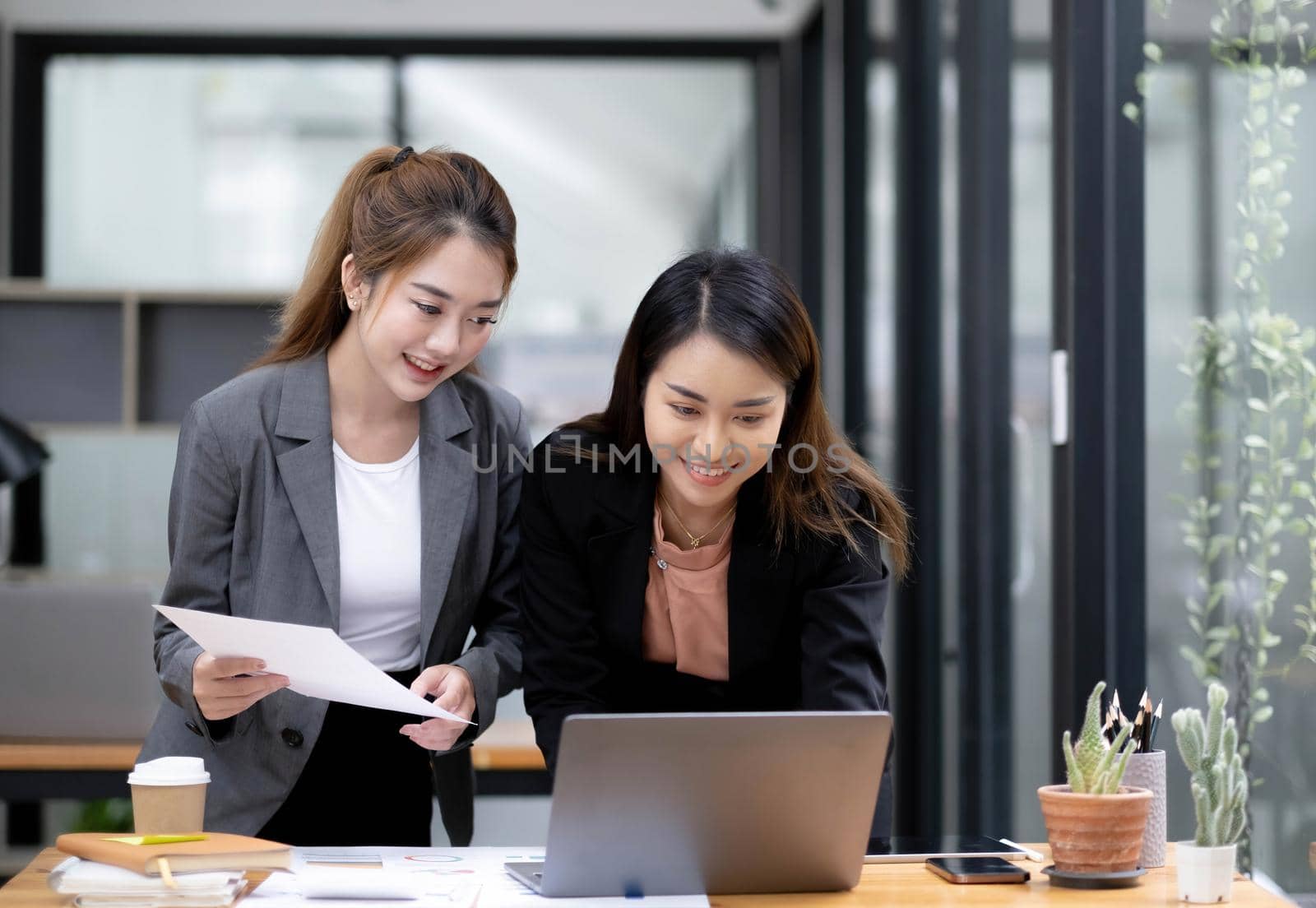 Two Young Asian businesswoman discuss with new startup project Idea presentation, analyze planning and financial statistics and investment market at office