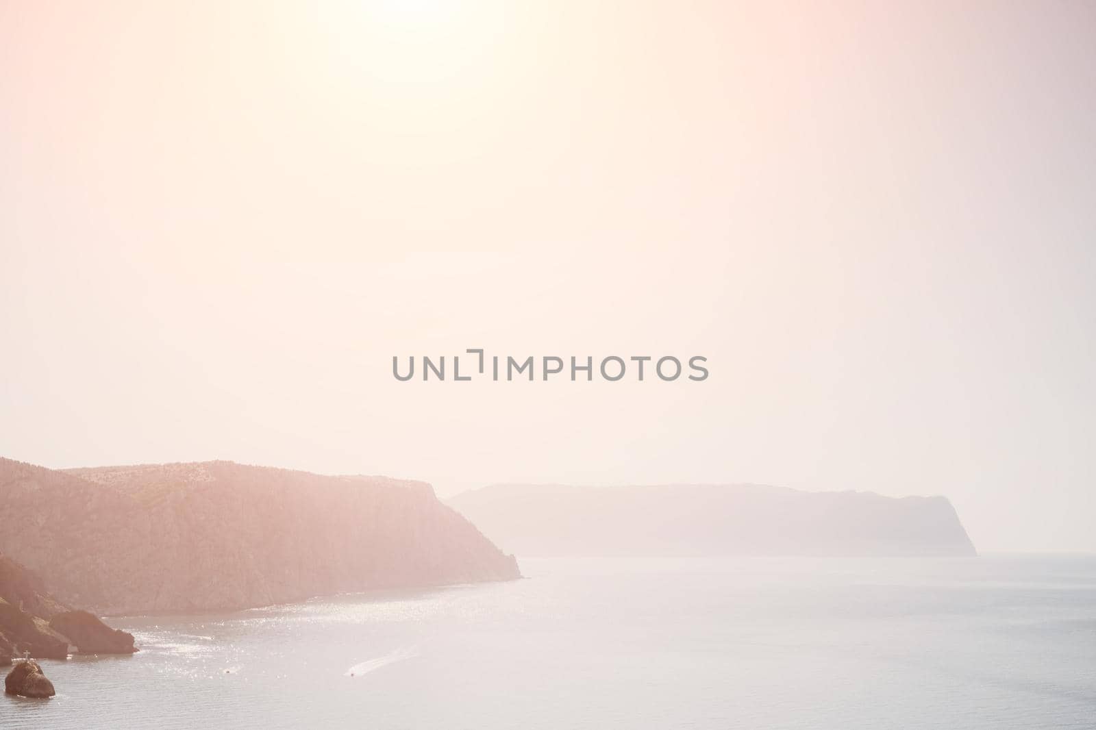 Abstract calm sea summer ocean sunset nature background. Small waves on water surface in motion blur with golden bokeh lights from sun. Holiday, vacation and recreational concept. Slow motion by panophotograph