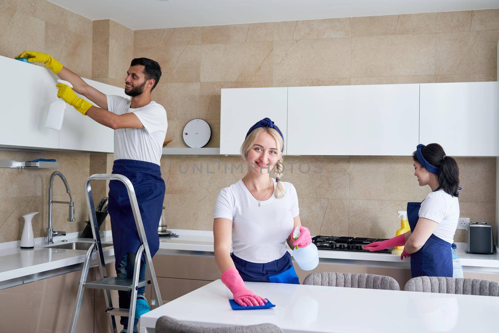 Cleaning service team at work in kitchen in private home by Mariakray