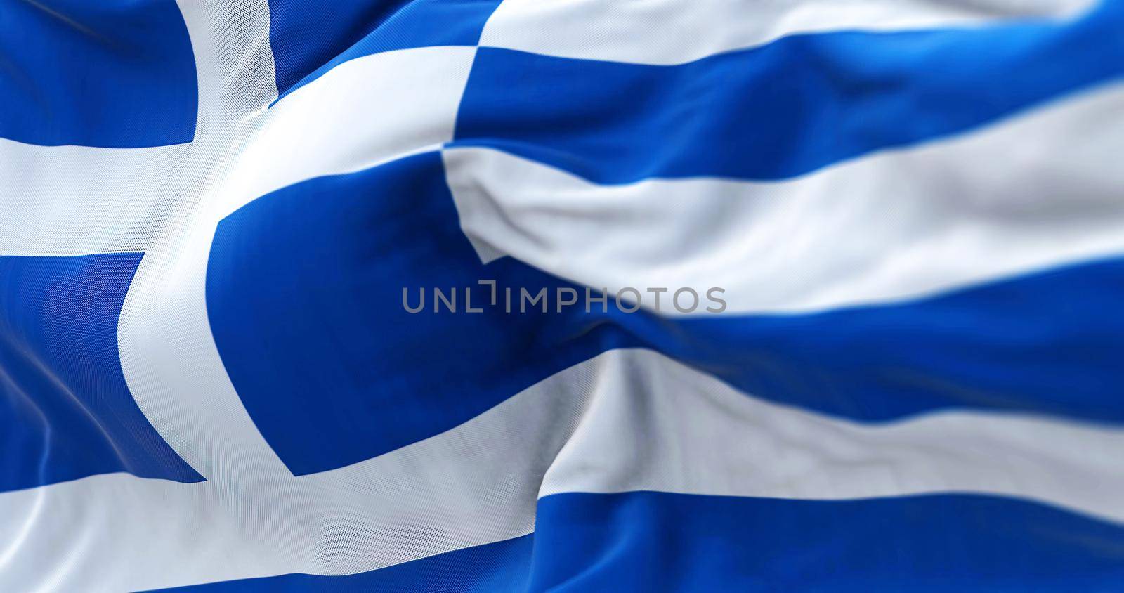 Close-up view of the greek national flag waving in the wind. Greece is a country at the crossroads of Central and Southeast Europe. Fabric textured background. Selective focus