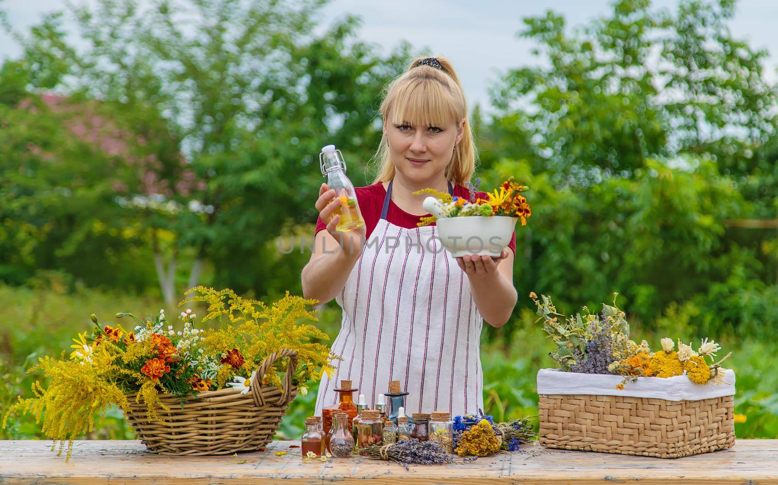 Woman with medicinal herbs and tinctures. Selective focus. Nature.