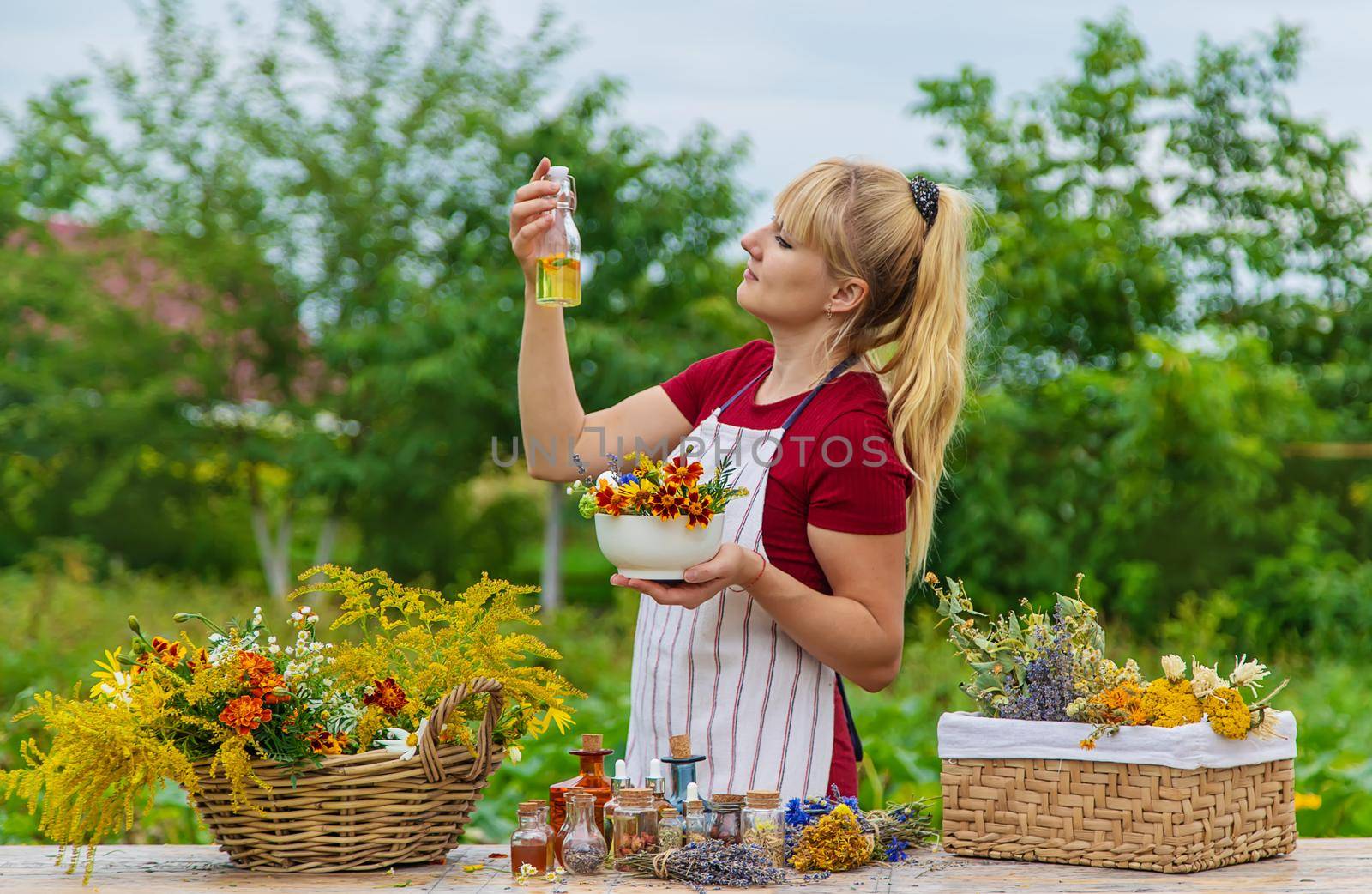 Woman with medicinal herbs and tinctures. Selective focus. Nature.