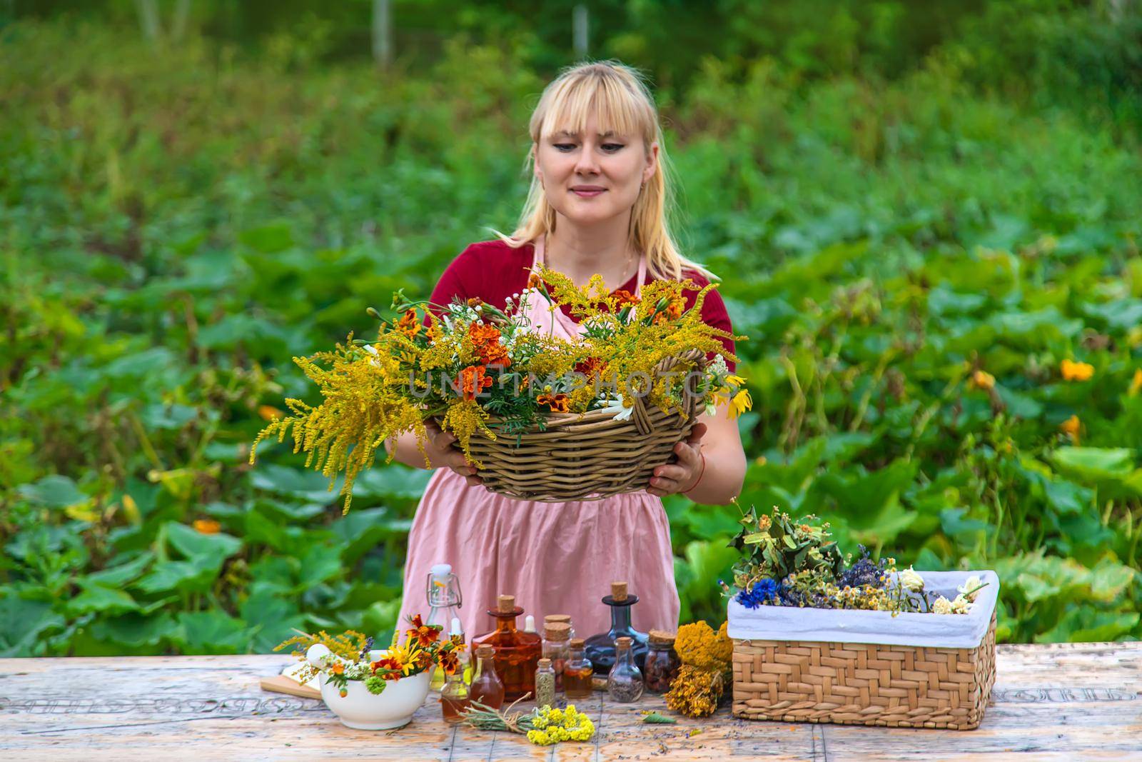 Woman with medicinal herbs and tinctures. Selective focus. Nature.