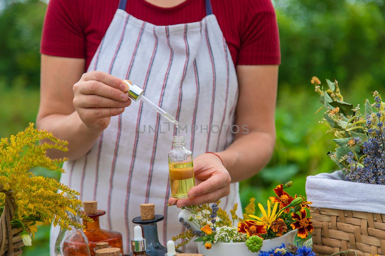 Woman with medicinal herbs and tinctures. Selective focus. Nature.