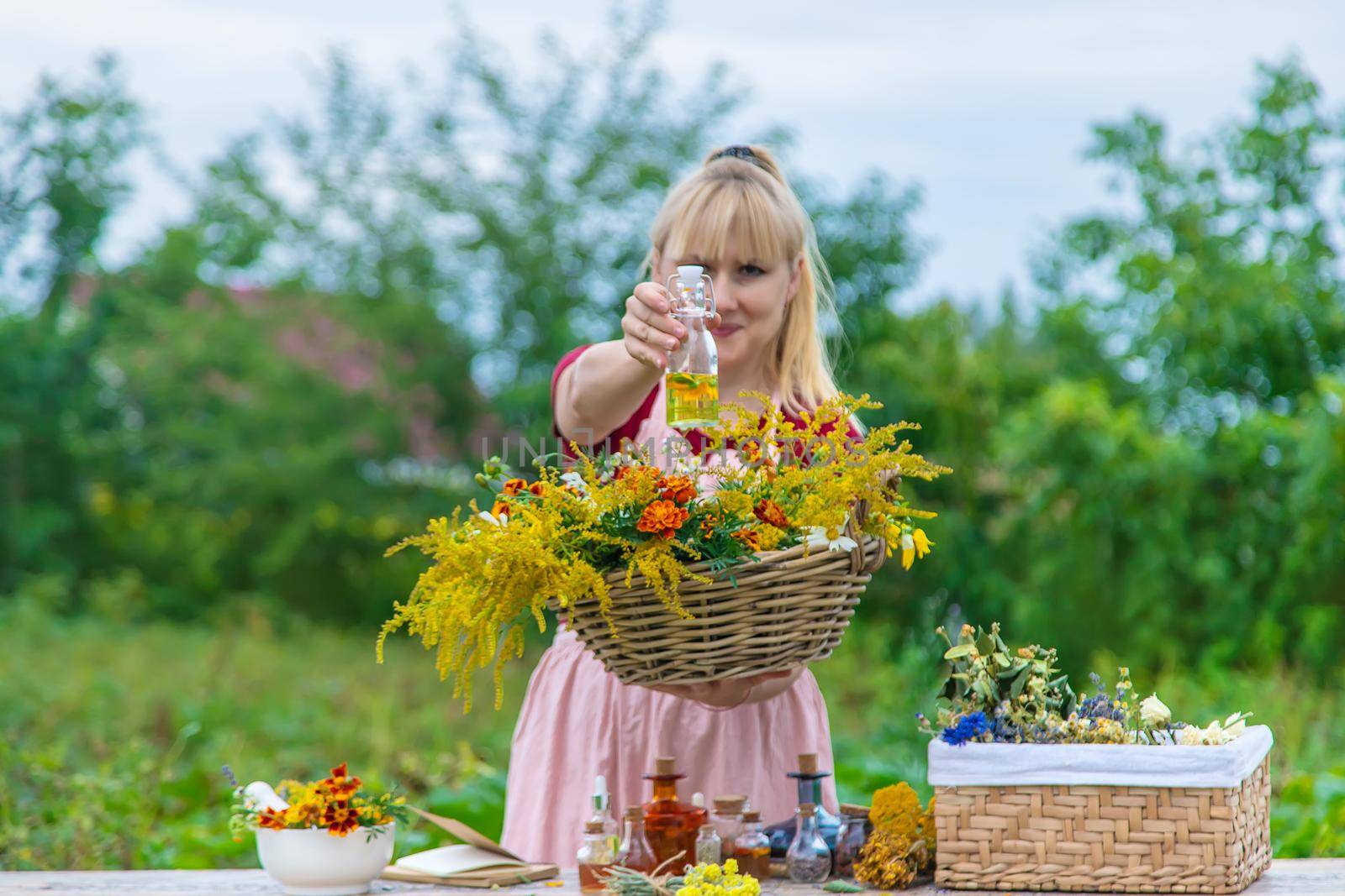 Woman with medicinal herbs and tinctures. Selective focus. Nature.