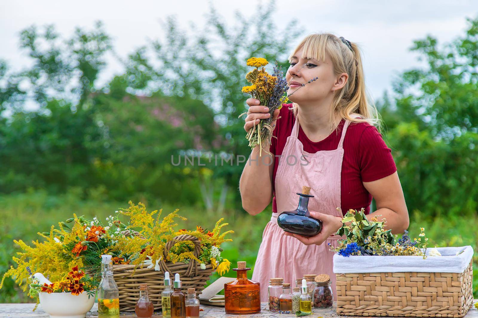 Woman with medicinal herbs and tinctures. Selective focus. Nature.