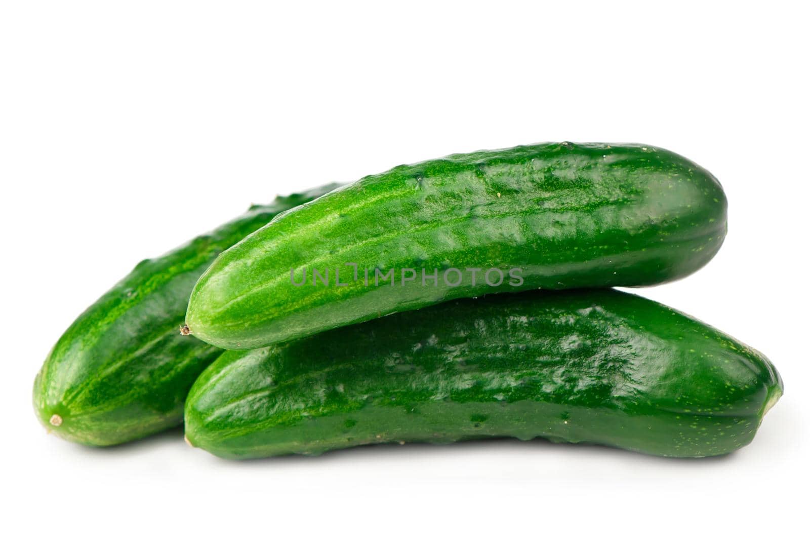 Cucumbers on white with green leaves on white by aprilphoto