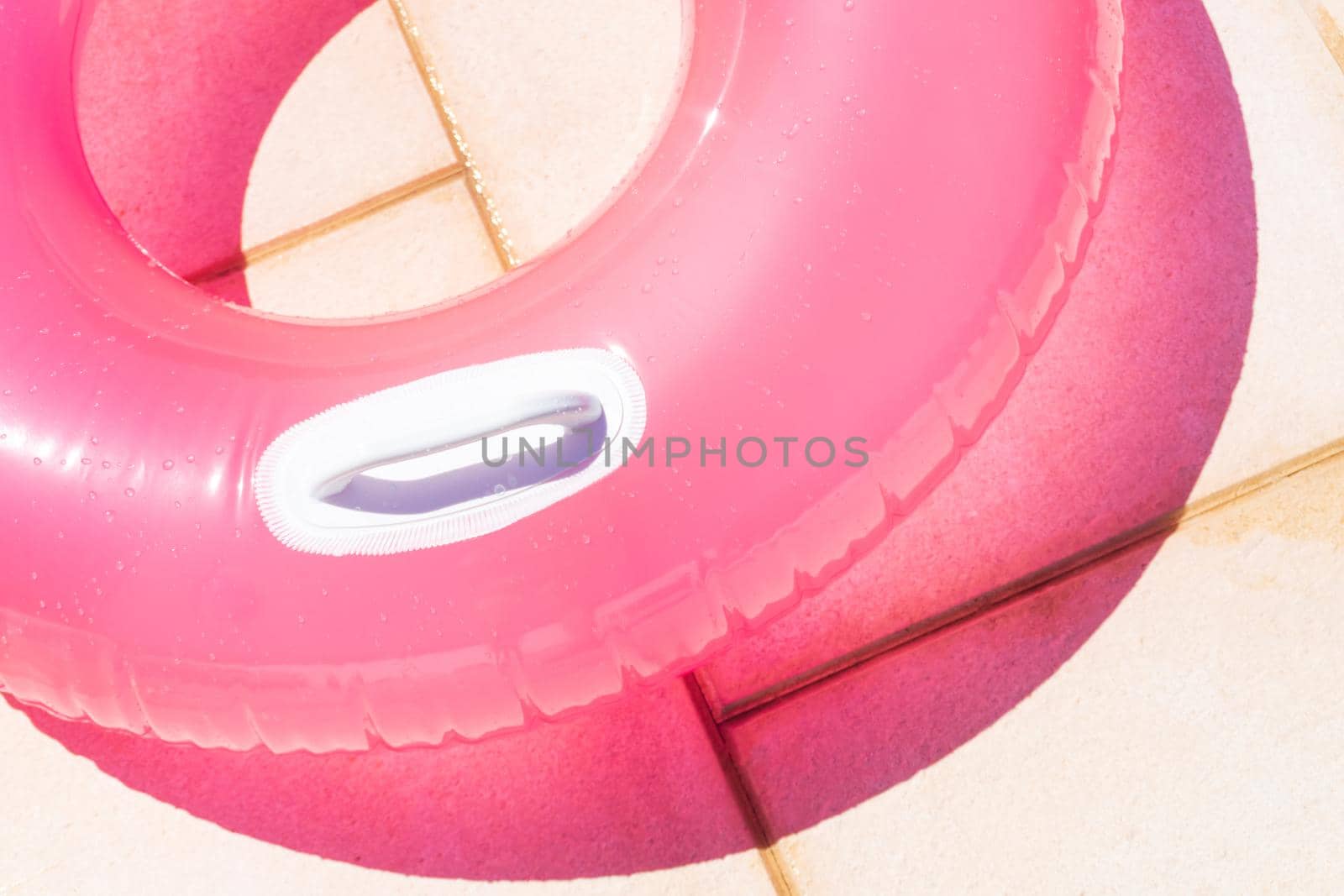 Translucent pink swim ring under the bright sun background