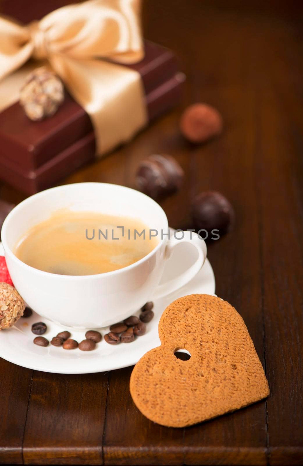 a cup of coffee and candy on vintage wooden background