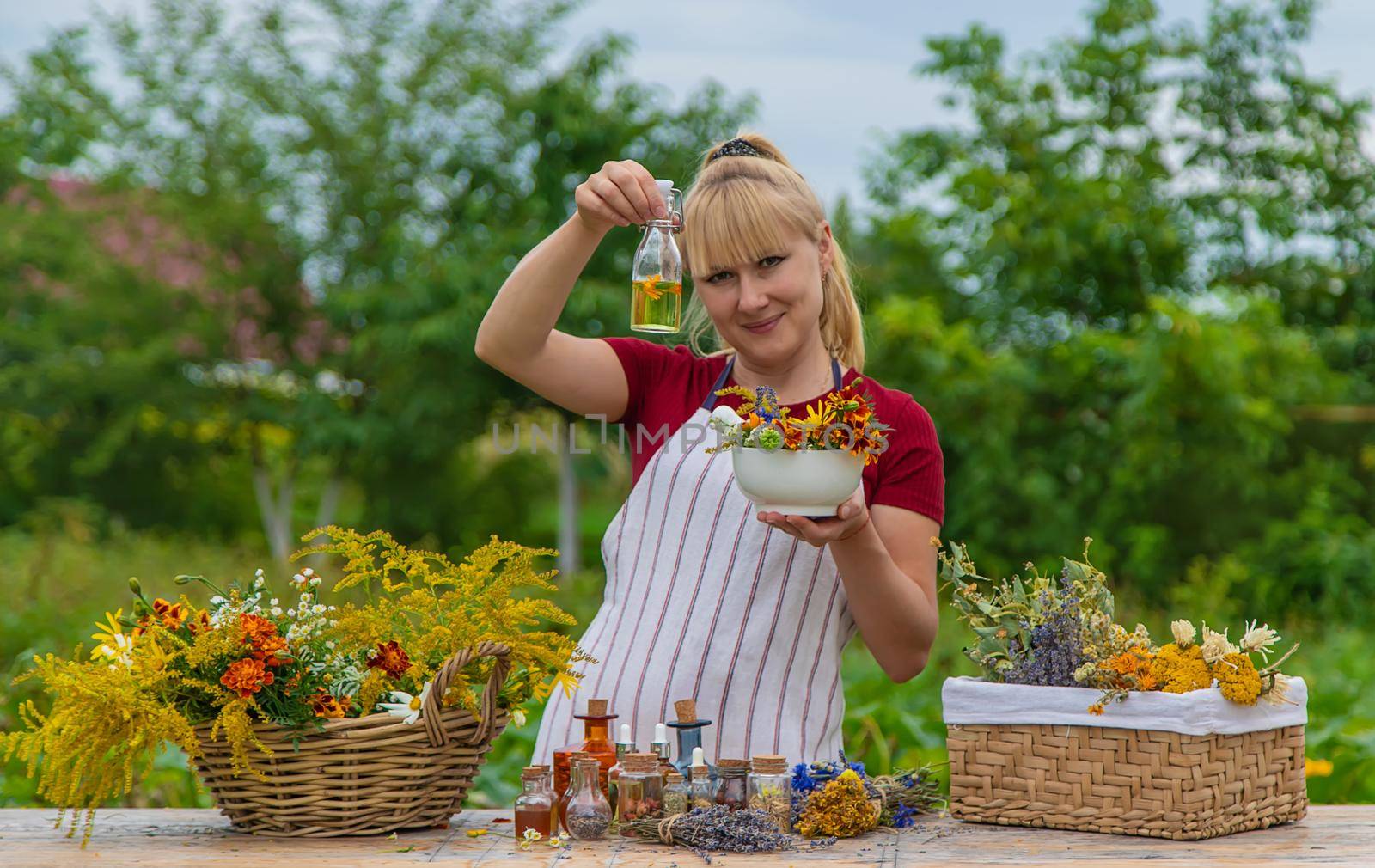 Woman with medicinal herbs and tinctures. Selective focus. Nature.