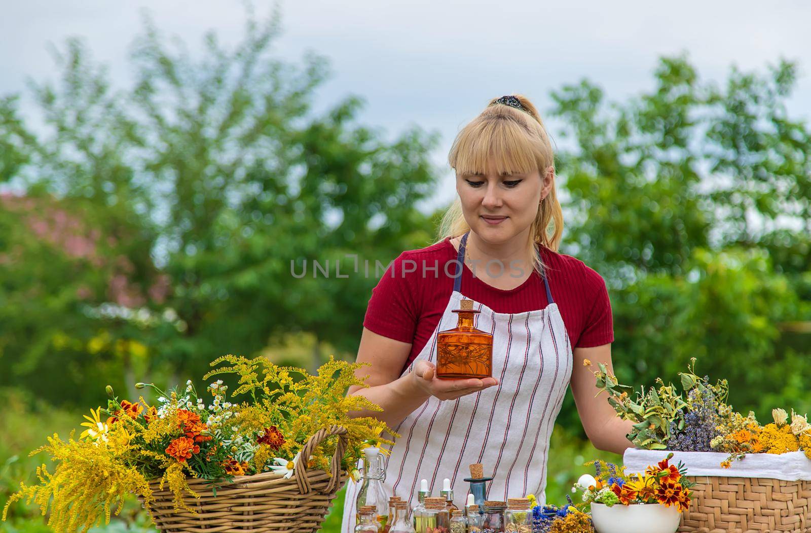 Woman with medicinal herbs and tinctures. Selective focus. Nature.