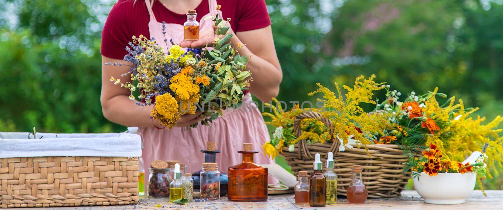 Woman with medicinal herbs and tinctures. Selective focus. Nature.