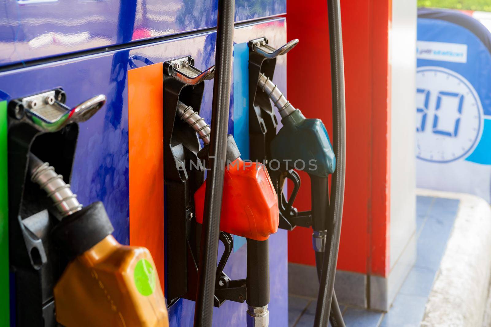 Petrol pump filling fuel nozzle in gas station. Fuel dispenser. Refuel fill up with petrol gasoline. Gas pump handle. Red petrol fuel nozzle. Petroleum oil industry. Oil crisis. Petrol price crisis. by Fahroni