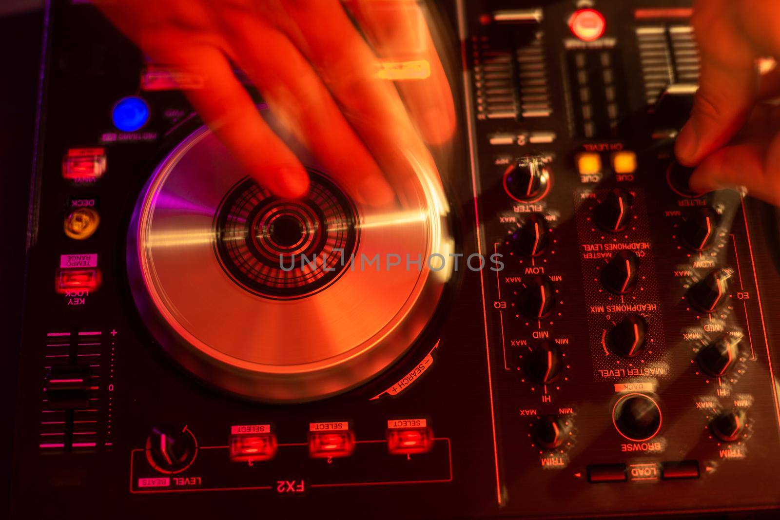 Dj mixing on turntables with color light effects. Soft focus on hand. Close-up. by nazarovsergey