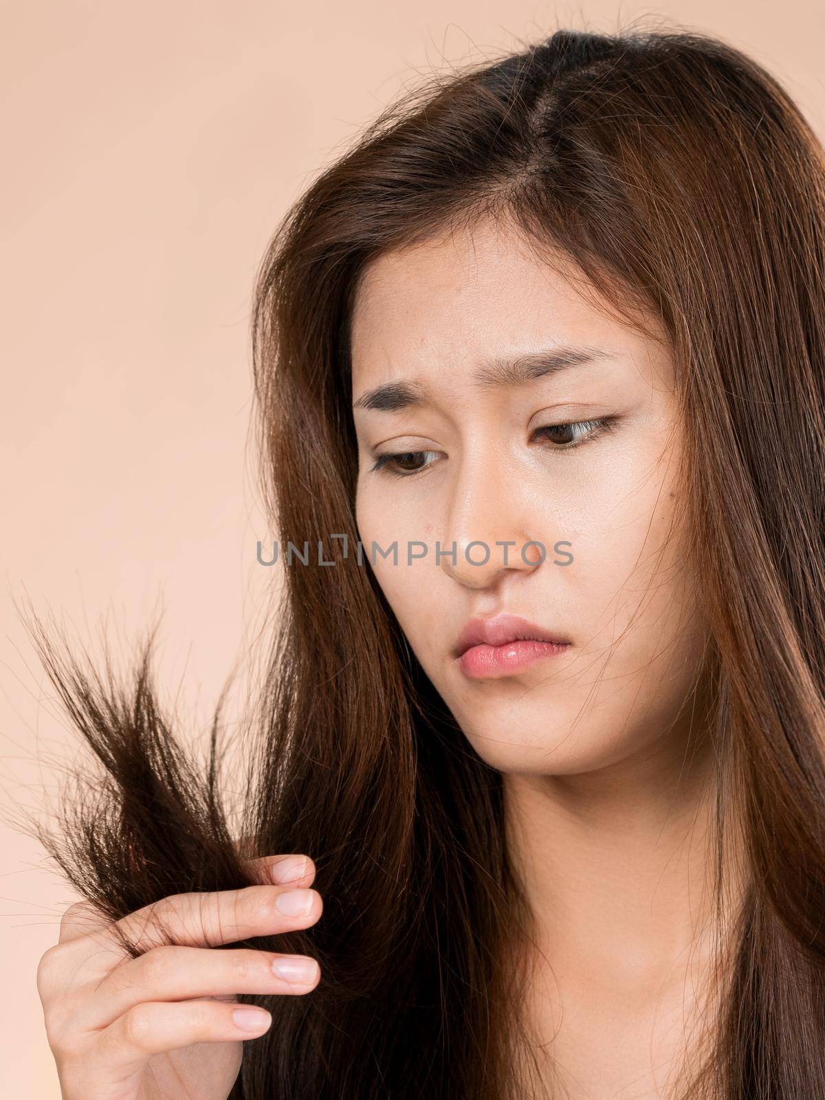 Ardent young girl feels insecure about her damaged hair. Beauty concept of brittle hair and how to treat it.