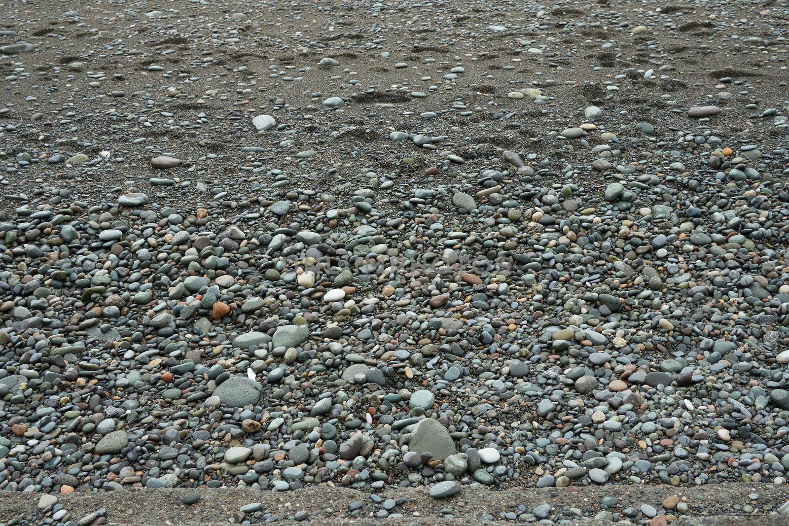 Pebbles on the shore close-up. Close-up of rounded and polished beach rocks.