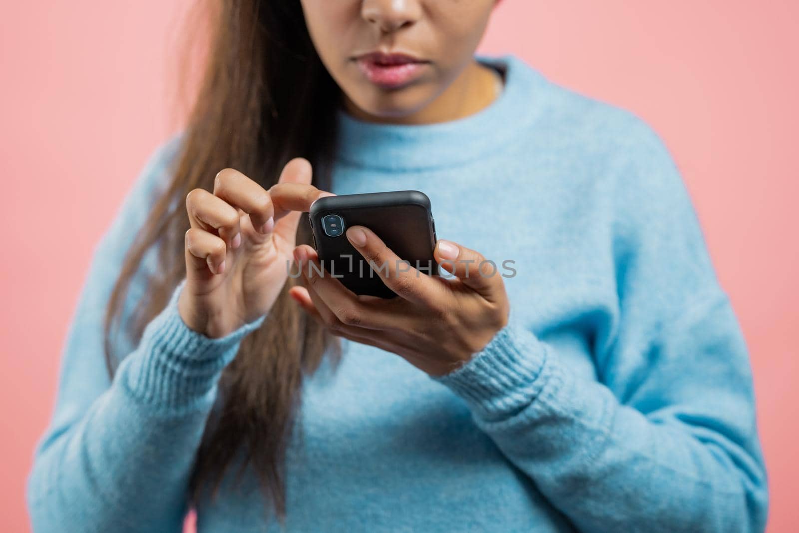 Hands of woman using smartphone on pink studio wall. Using modern technology - apps, social networks. by kristina_kokhanova