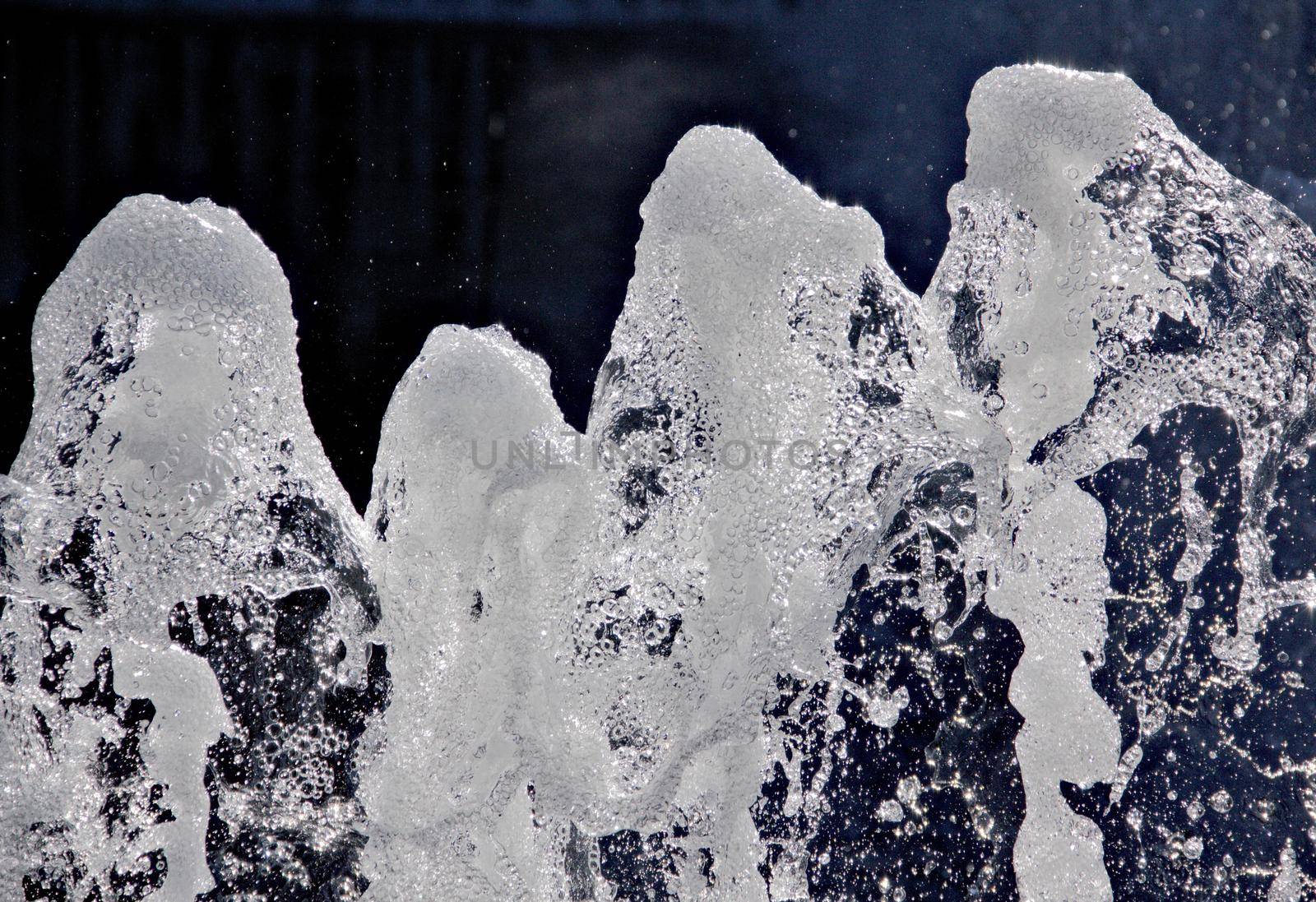 A close-up of the splashing waterfall of the fountain. by gallofoto