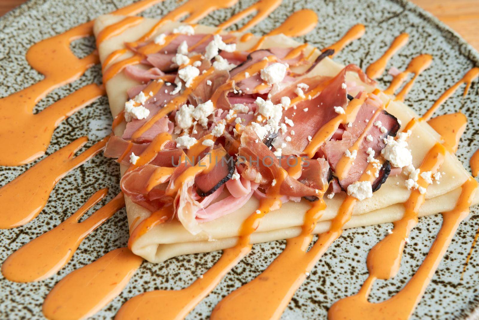 photo of delicious salty crepe with serrano ham, cream cheese and chipotle dressing. salty crepe.