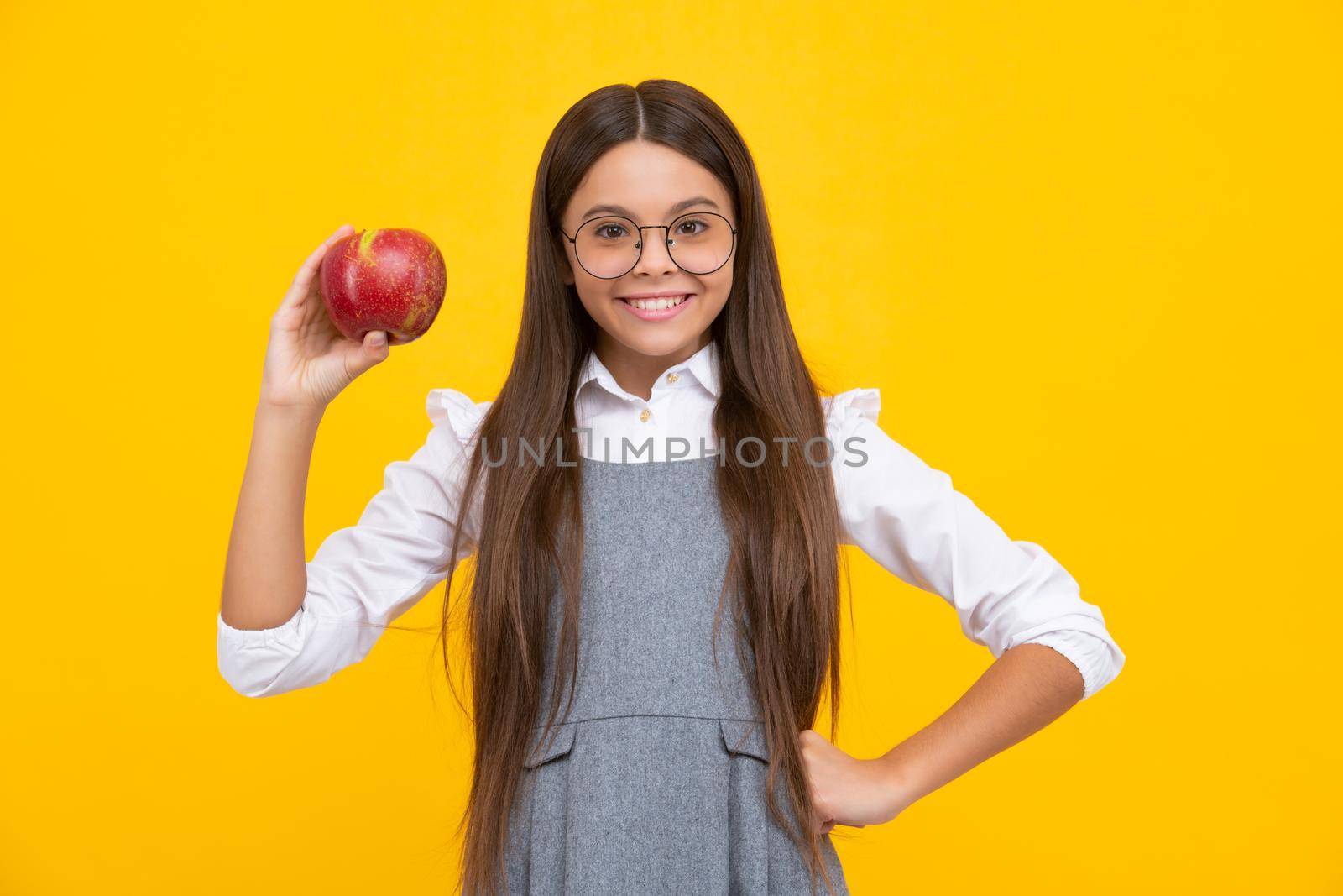 Teenager child with apple on yellow isolated background. apples are good for children. Happy girl face, positive and smiling emotions