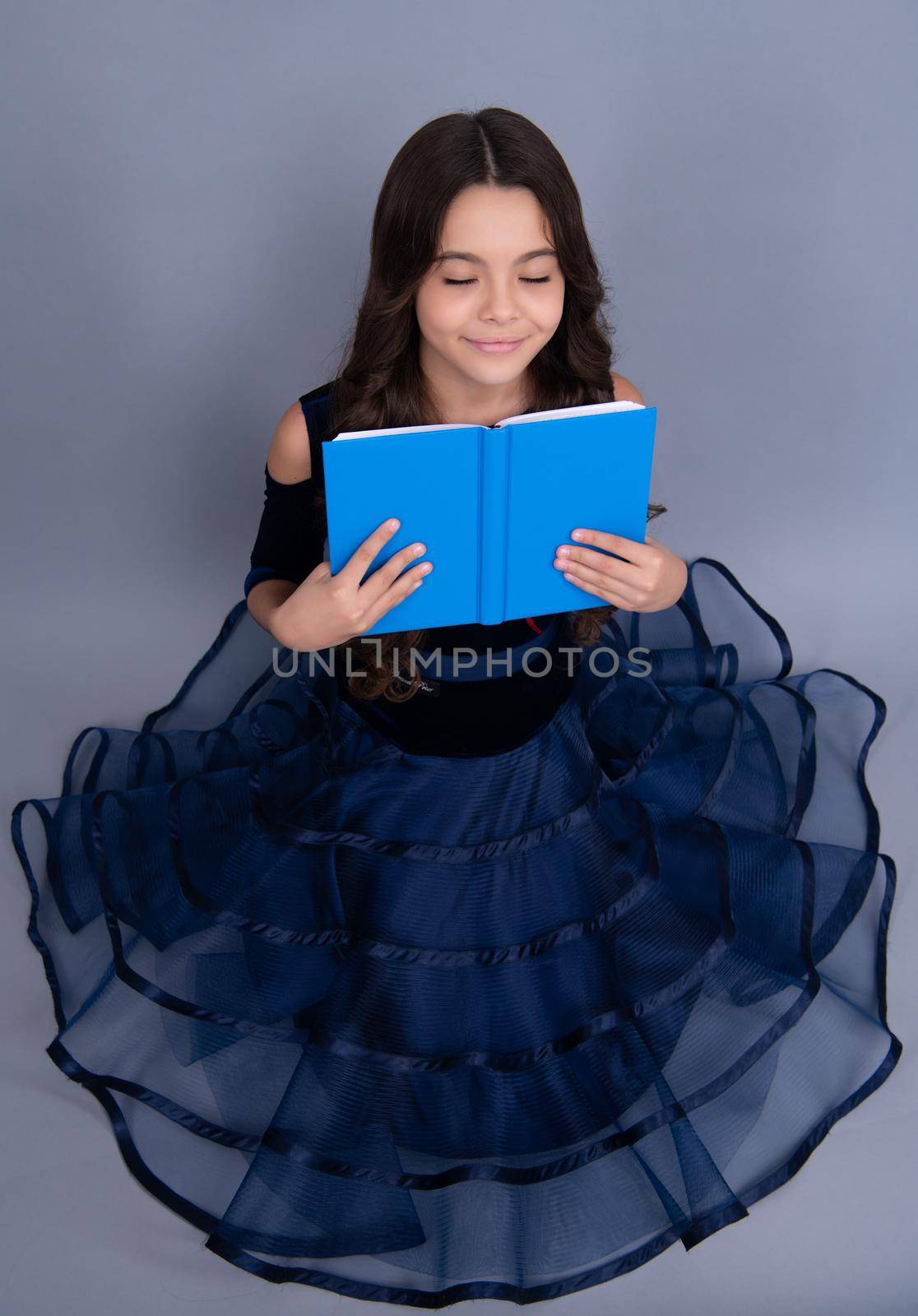 Dreaming schoolgirl in dress hold book and copybook ready to learn. School children dream on isolated grey background