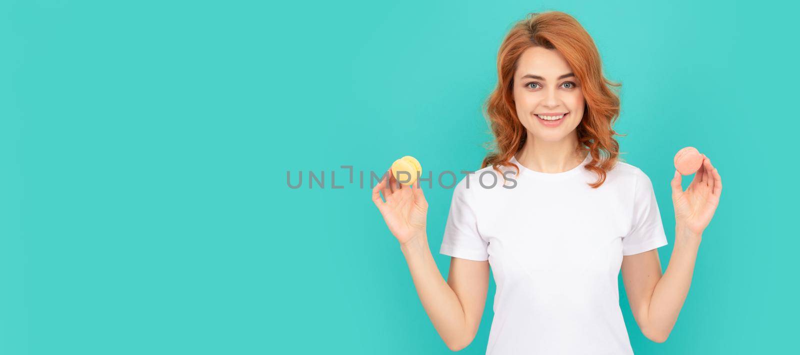 happy woman hold sweet macaron french cookie on blue background. Woman isolated face portrait, banner with mock up copyspace