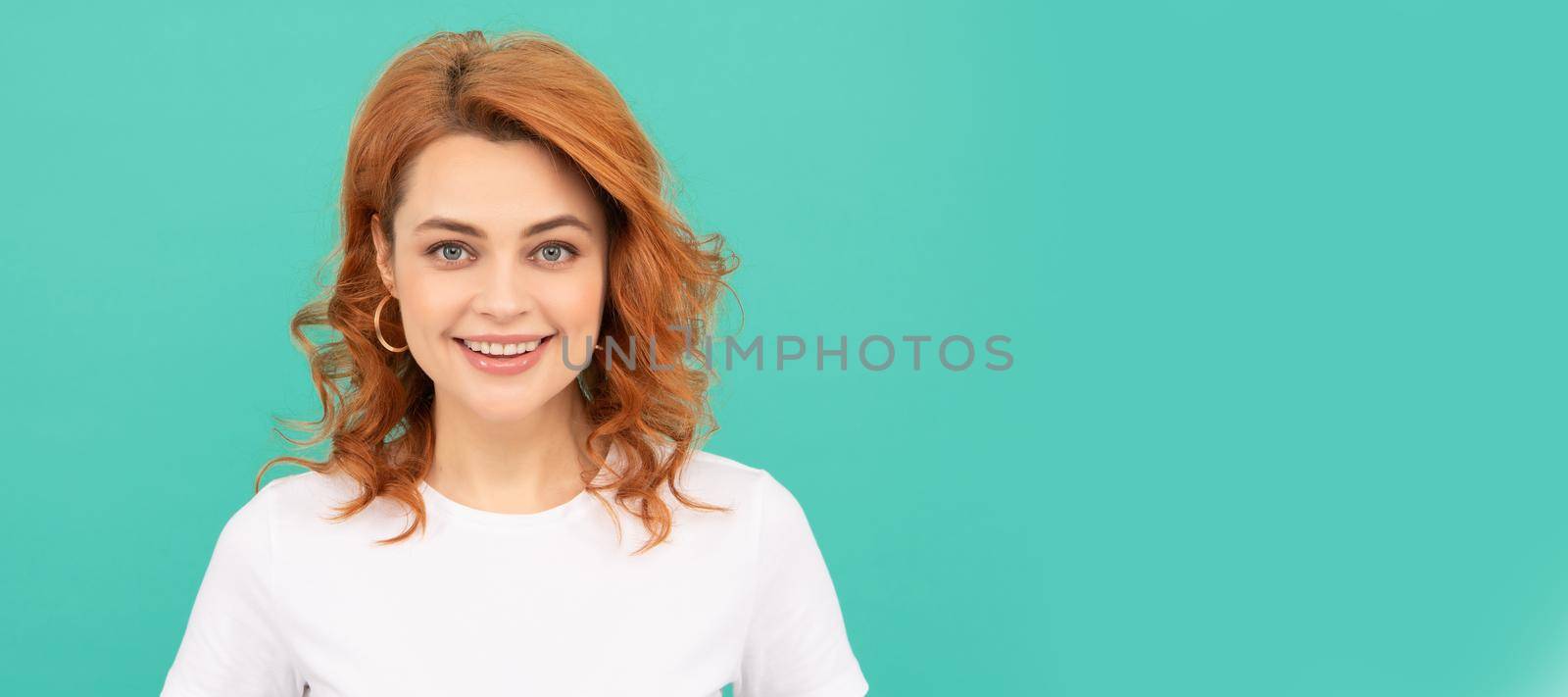 happy redhead woman with curly hair on blue background. Woman isolated face portrait, banner with copy space. by RedFoxStudio