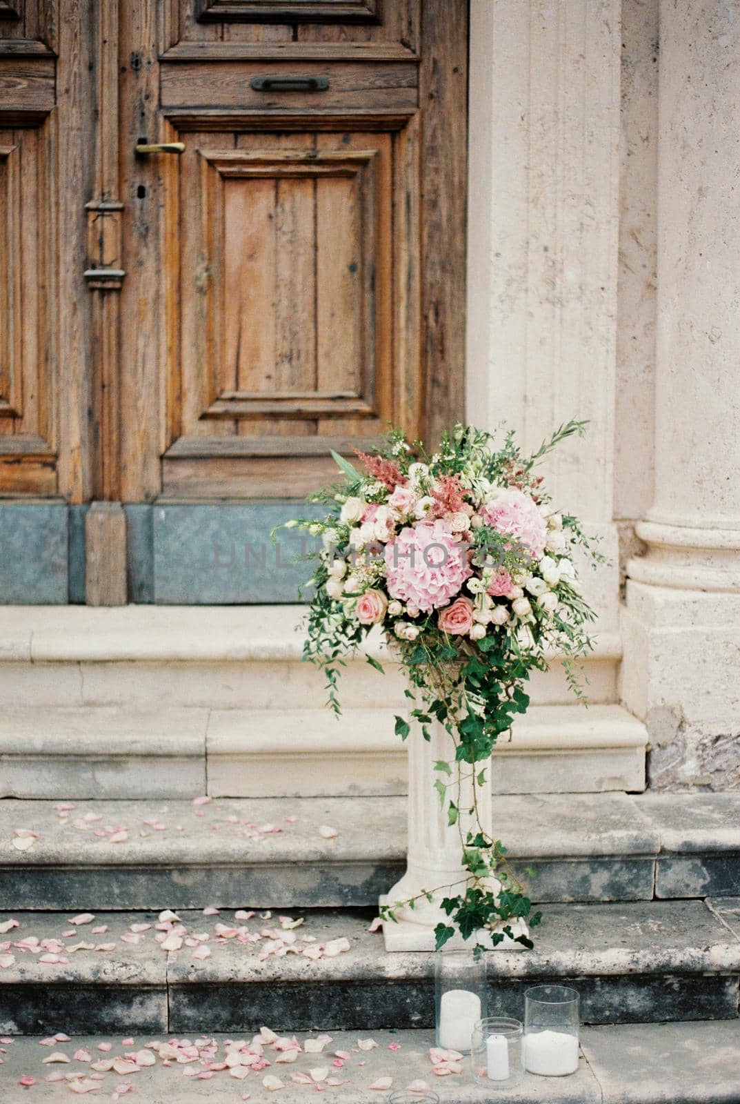 Bouquet of flowers stands on a stone pedestal on the steps of the church. High quality photo