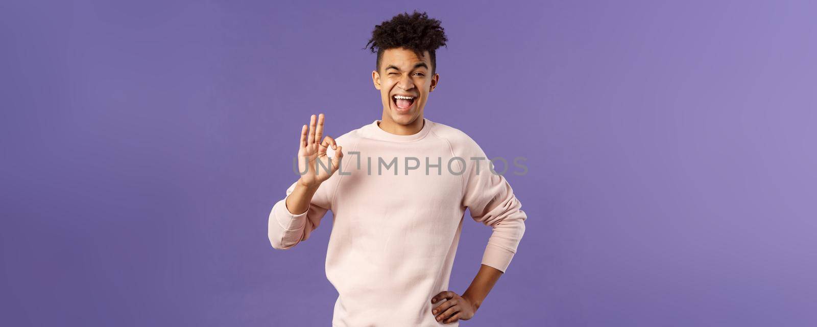 Portrait of enthusiastic young relaxed man show no problem, guarantee gesture, recommend awesome courses where you easily learn new languages, smiling and show ok to assure you by Benzoix