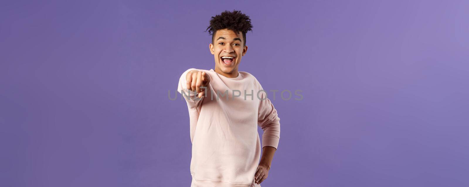 Portrait of outgoing happy hispanic male student making his choice, laughing over something extremely funny point finger at camera with amused smile, standing purple background by Benzoix