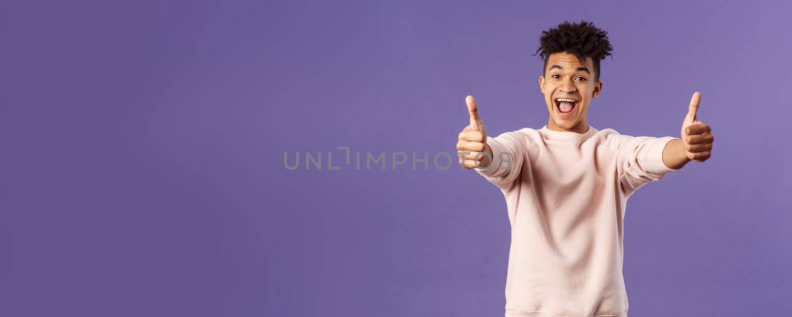 Portrait of satisfied young happy man think event was super cool, recommend use company service, assure in best quality, like and approve awesome product, standing purple background.