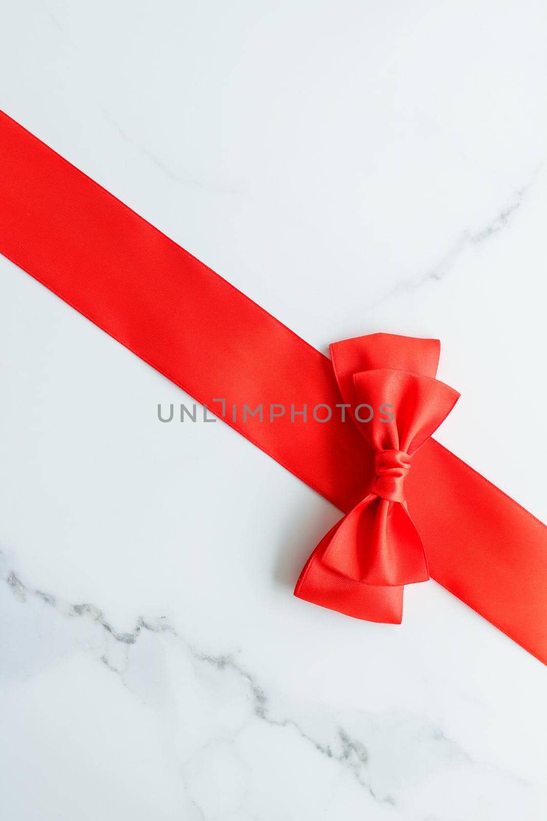 Red silk ribbon on marble, top view by Anneleven