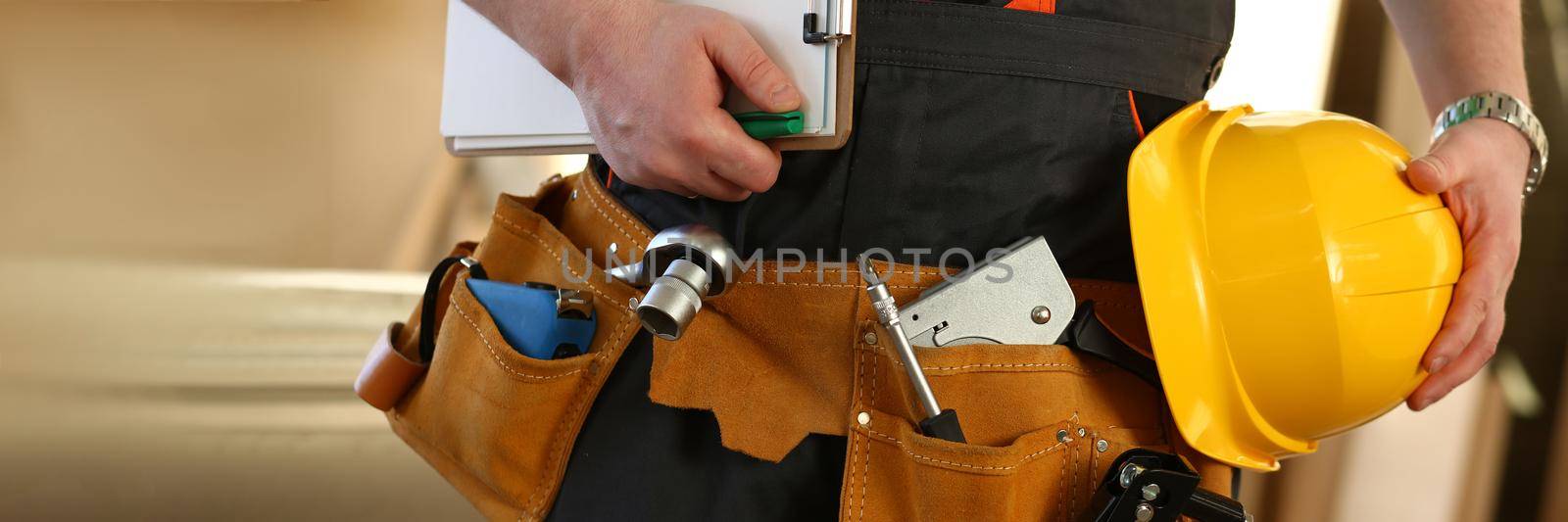 Cropped professional builder holding construction tools and helmet by kuprevich