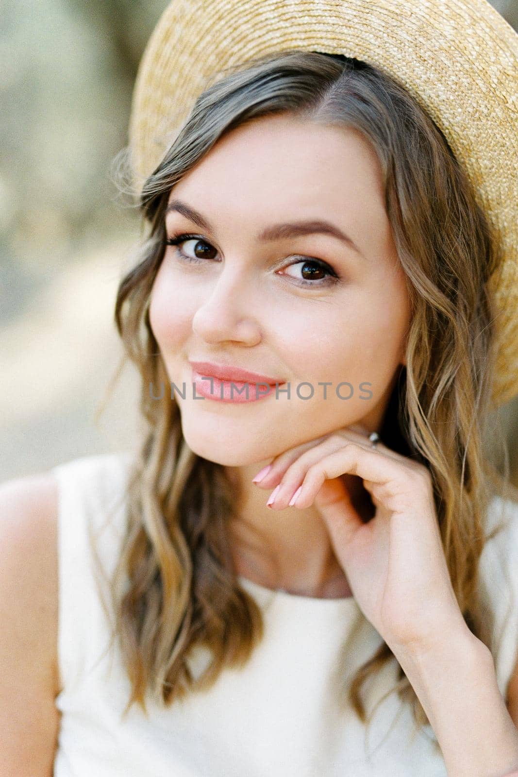 Young woman in a straw hat resting her chin on her hand. High quality photo
