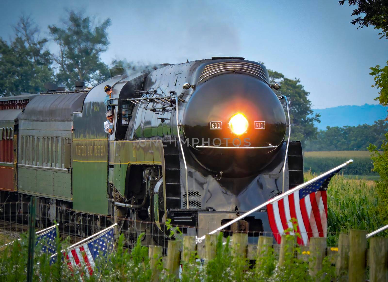 Ronks, Pennsylvania, July 24, 2021 - An Antique Steam Passenger Train Traveling Thru Farmlands Puffing Lots of Smoke on a Cloudy Winter Day