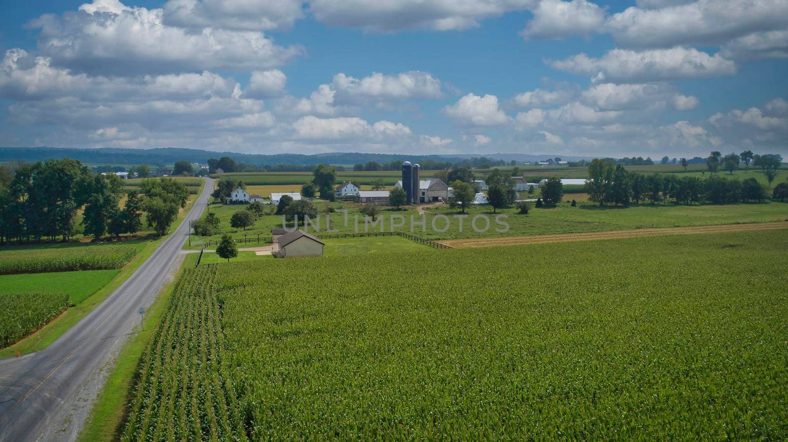 Drone View of Amish Countryside With Barns and Silos, a Patch Work of Corps and Farmlands on Sunny Day.