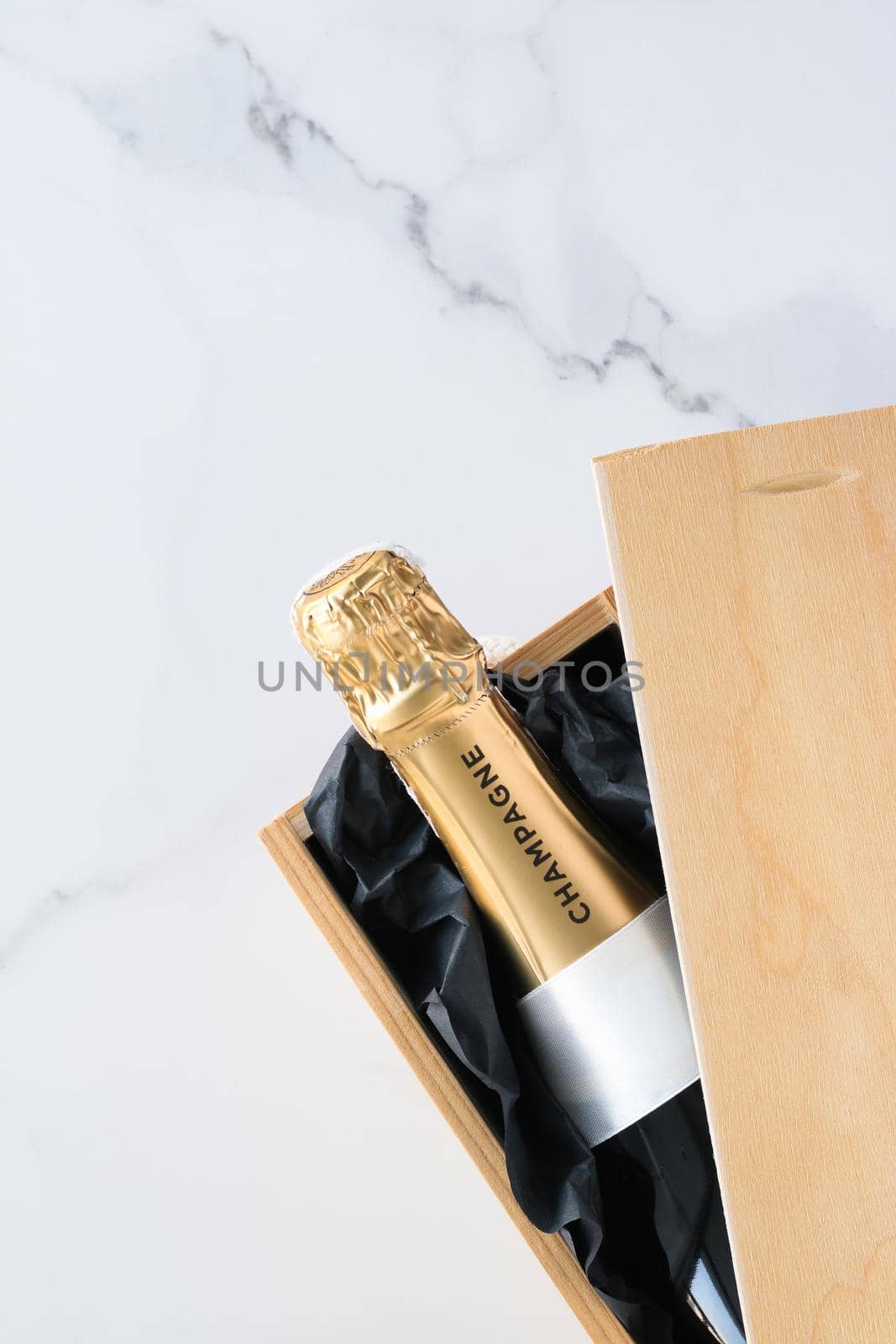 Wedding celebration, lifestyle and luxury present concept - A champagne bottle and a gift box on marble