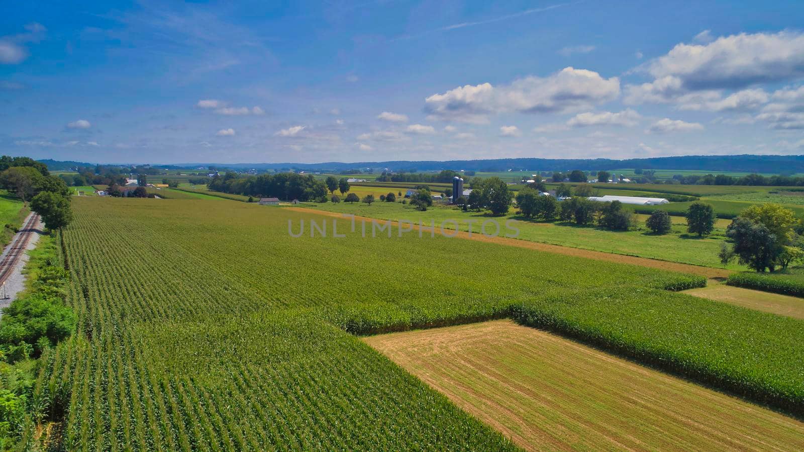 Drone View of Amish Countryside With Barns and Silos and Corn, Patch Work of Color and Corps, on Sunny Day.