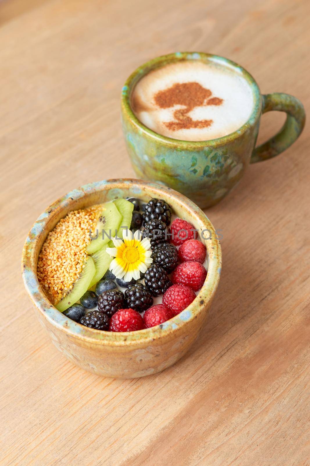 bowl of oatmeal with strawberry and granola on a wooden table. healthy breakfast.