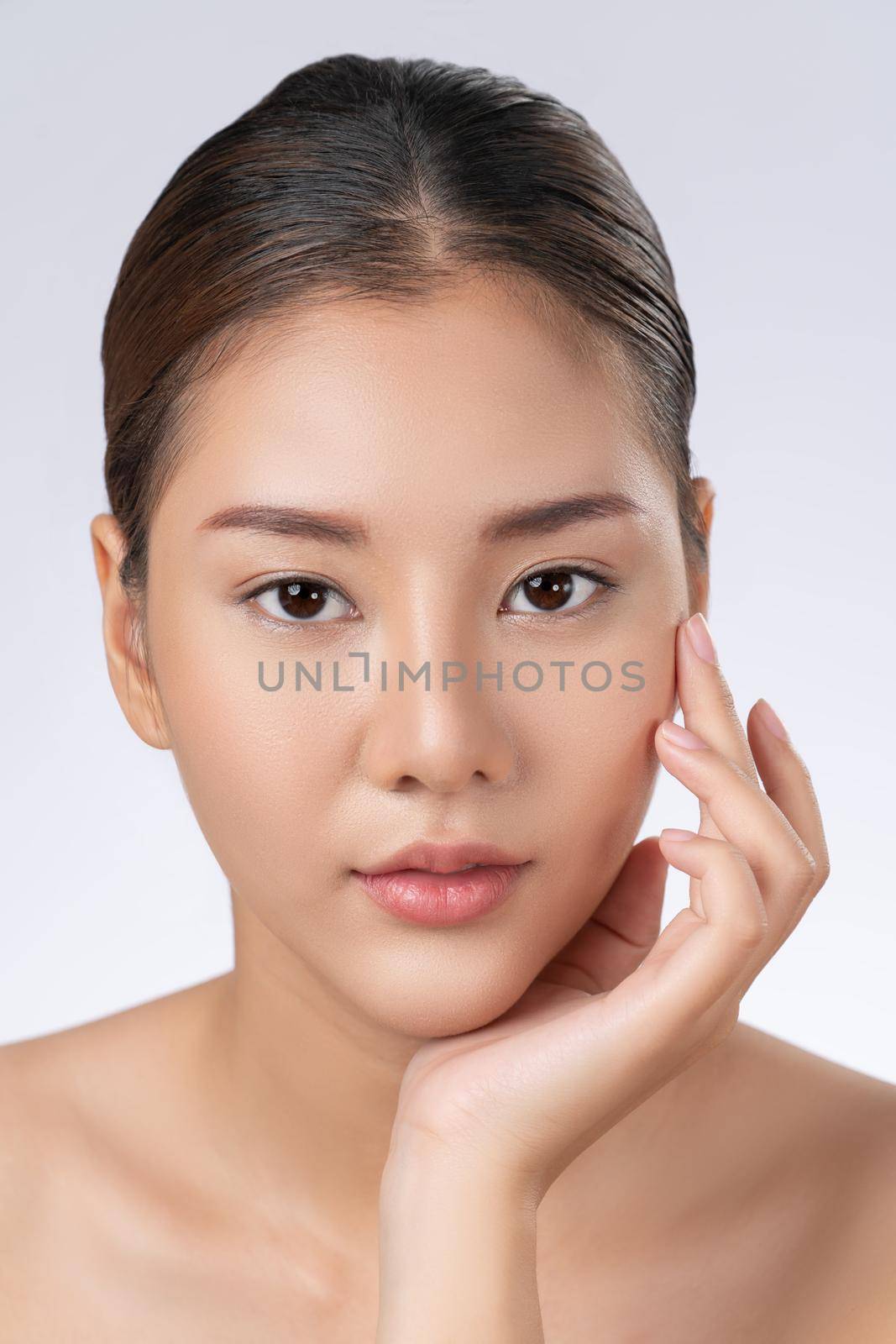 Close up portrait of gorgeous young girl posing beauty gesture with healthy clear skin and soft makeup. Cosmetology and beauty concept.