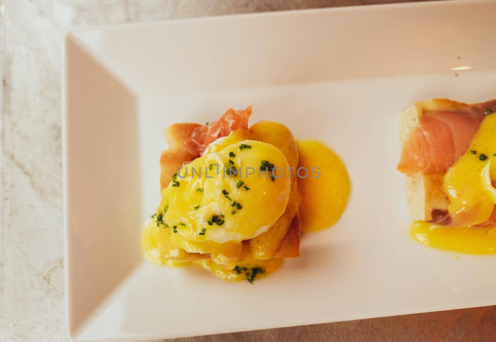 Restaurant service, food recipes and breakfast concept - Poached egg with salmon for brunch in a luxury restaurant