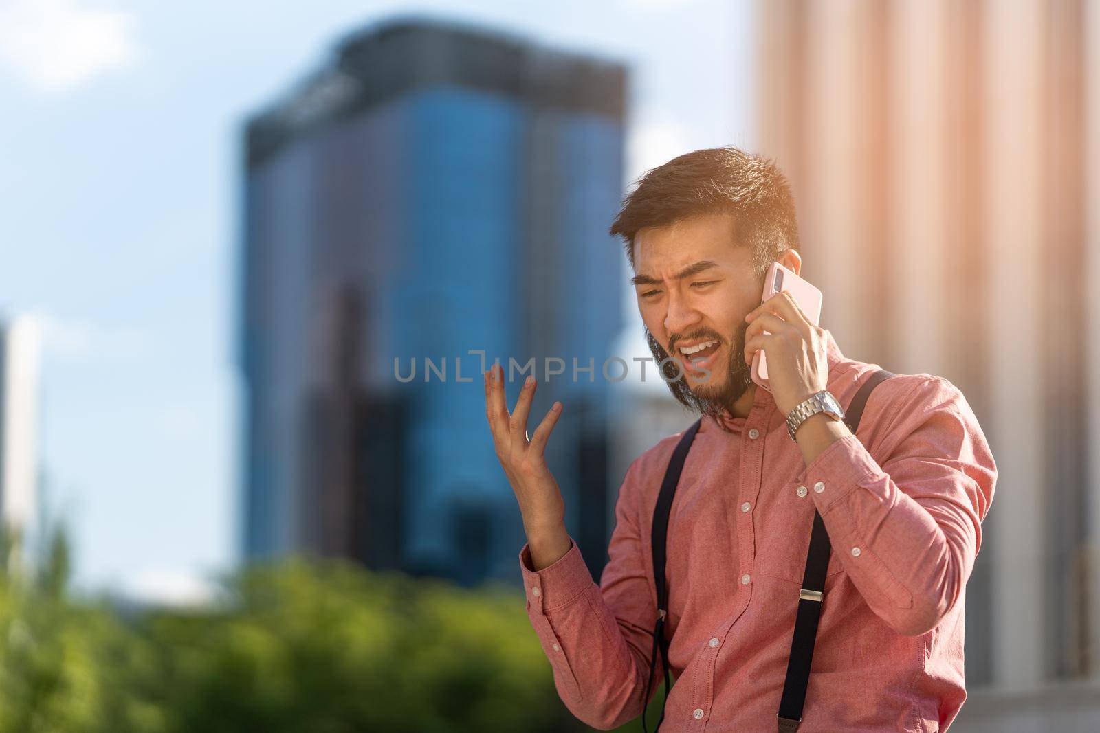 Asian businessman talking on his mobile angrily by ivanmoreno