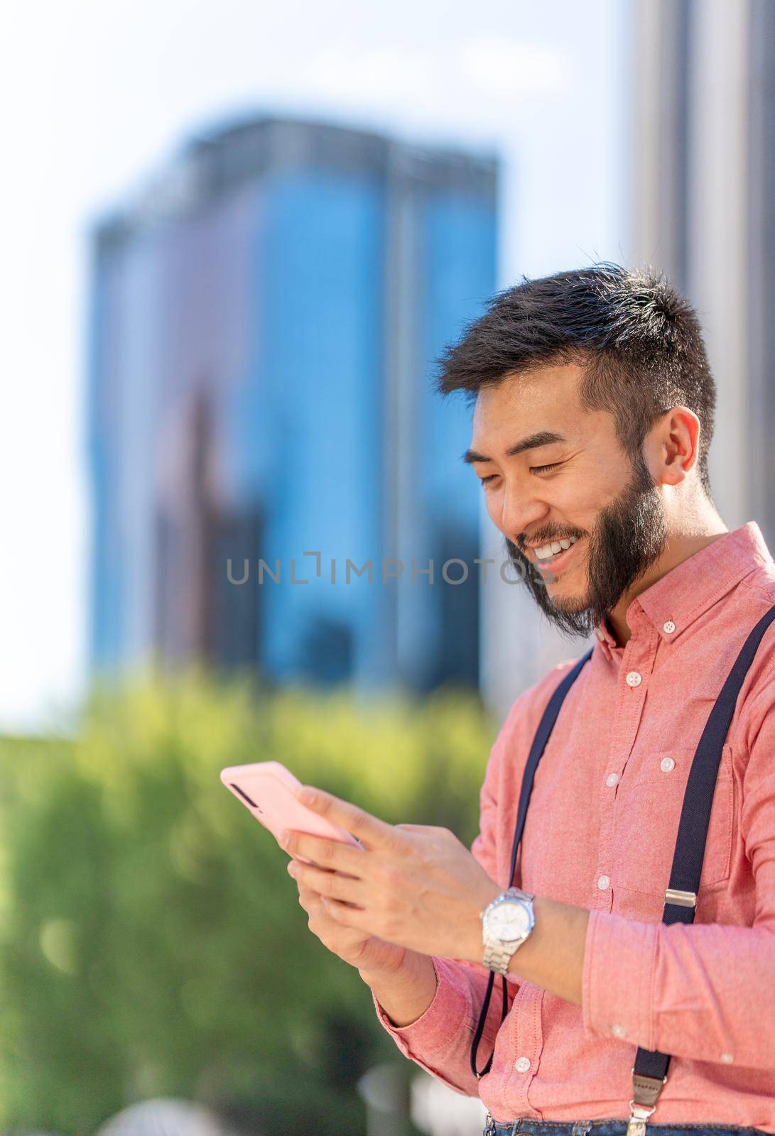 Vertical photo of a happy asian businessman using a mobile by ivanmoreno