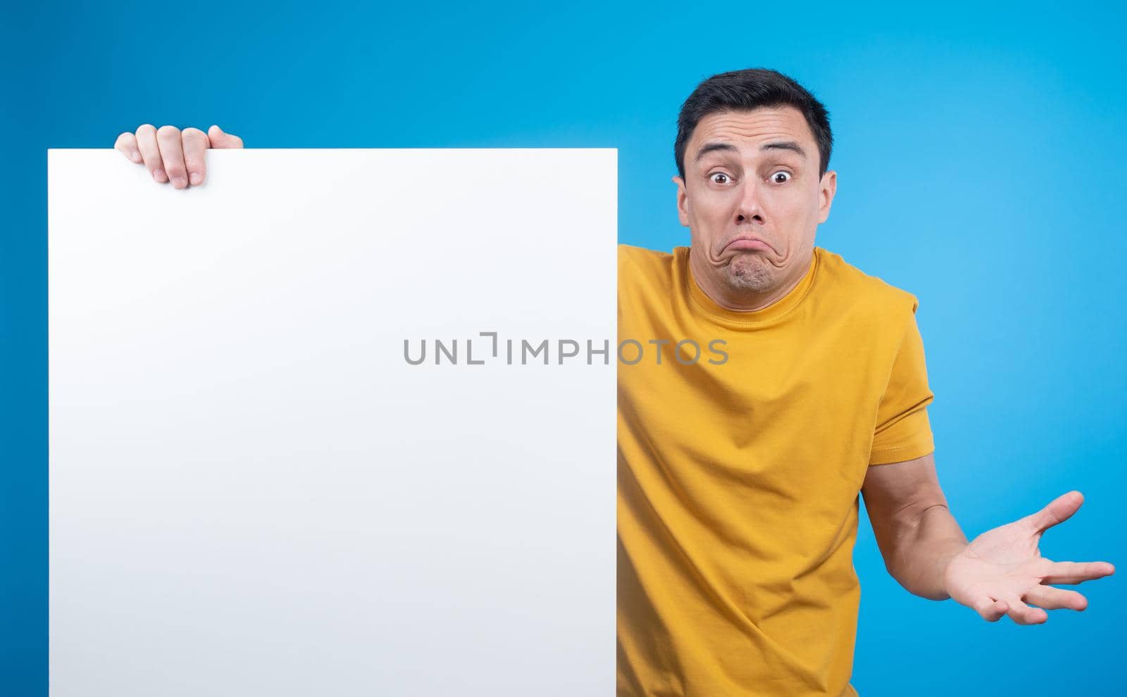 Unsure man shrugging shoulders and showing blank banner by ivanmoreno