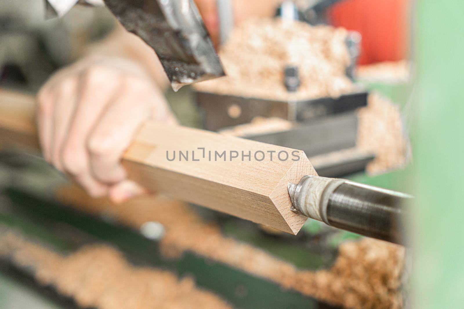 Crop handyman operating wood turning machine at work by ivanmoreno