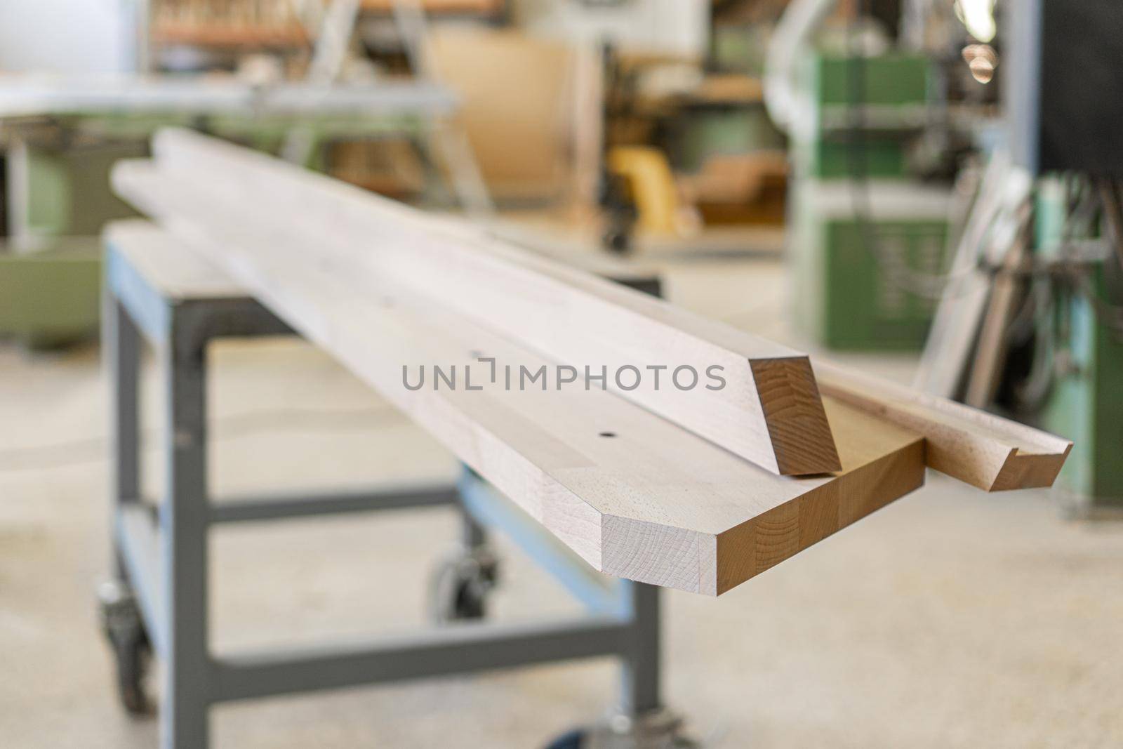 Selective focus of long timber detail placed on workbench in light contemporary carpentry workshop