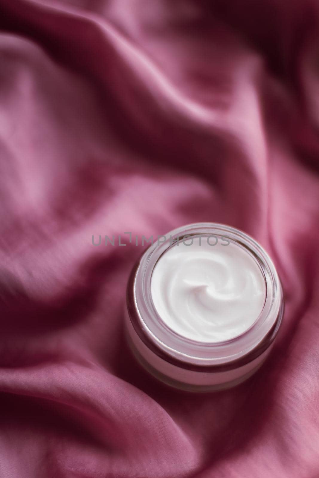 Beauty, anti-age cosmetics and skincare concept - Luxury face cream jar on a soft pink silk