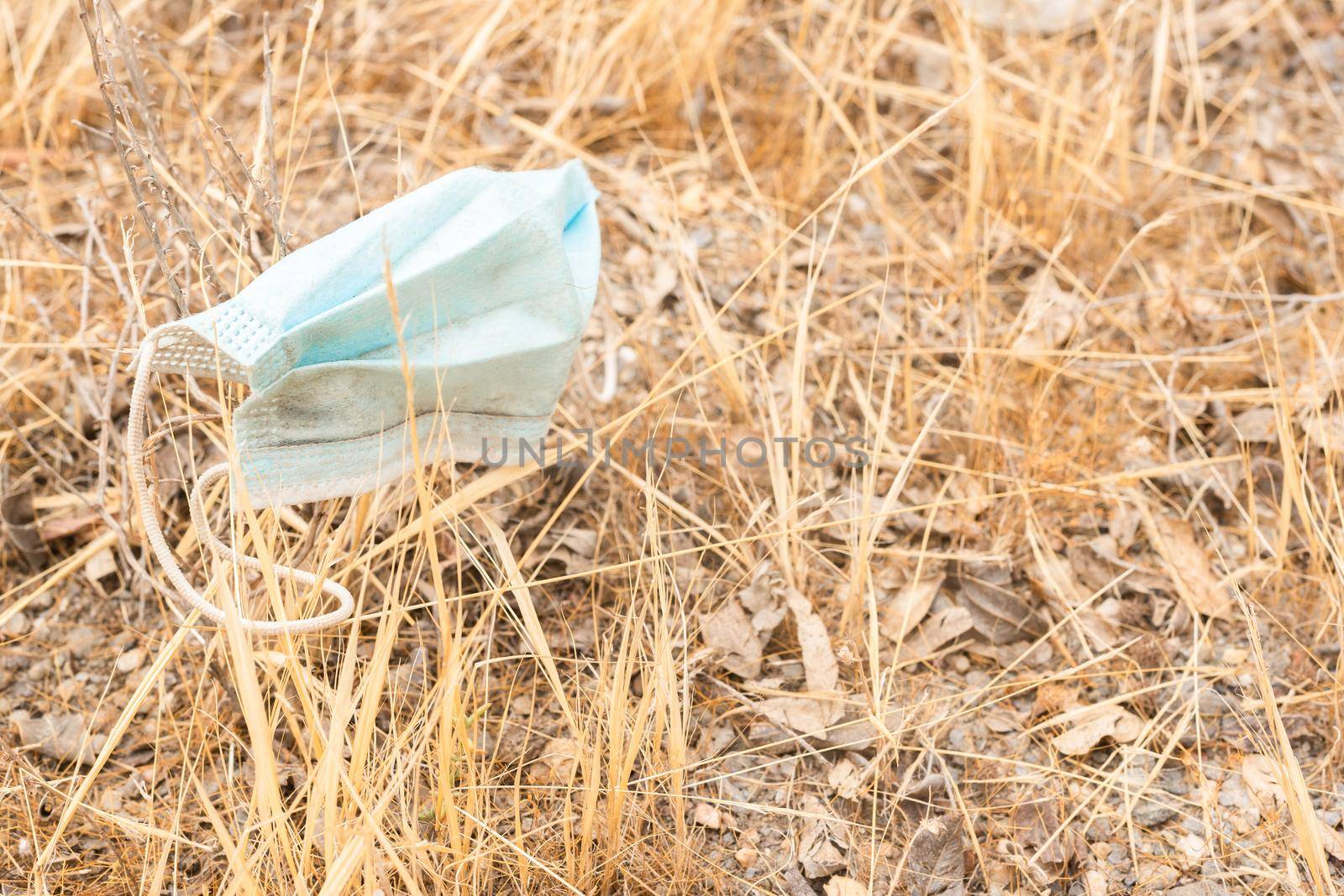 Medical mask placed on dry withered grass by ivanmoreno